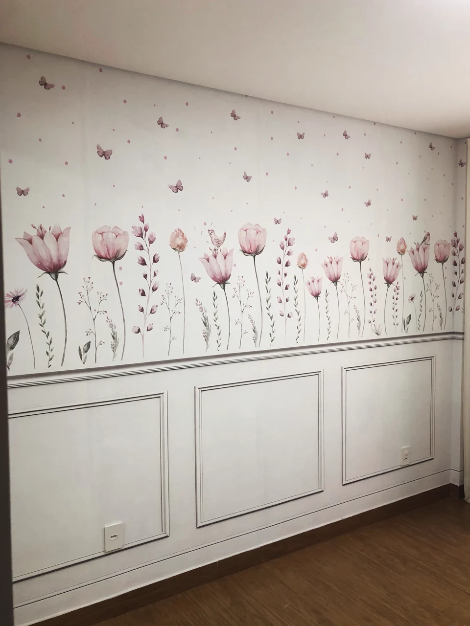Papel de parede floral aquarelado com molduras de boiserie em quarto infantil
